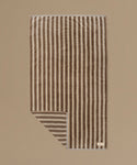 Striped towel with brown and beige stripes on a beige background