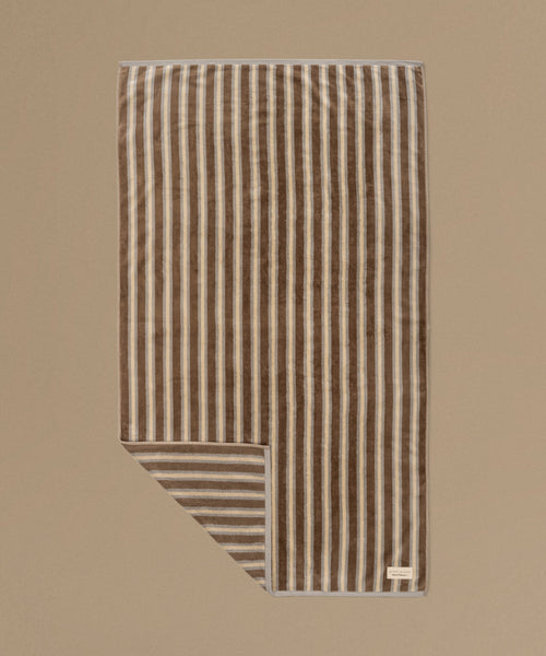 Striped towel with brown and beige stripes on a beige background
