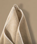 Beige towel hanging against a beige background