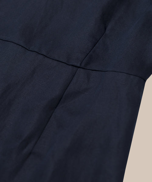 Close-up of the Blair Dress in dark navy blue linen, showing visible stitching and seam details—perfect for a spring wardrobe—set against a plain light background.
