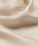 A close-up view of the Blair Dresss soft beige fabric, showing gentle folds and a smooth texture with a light sheen—ideal for adding breezy elegance to your spring wardrobe.