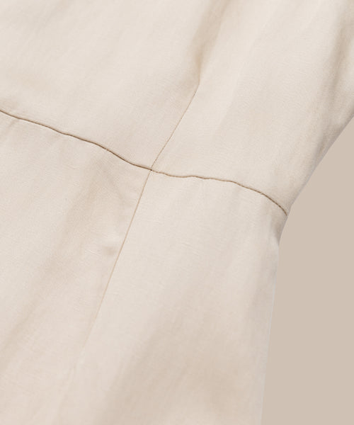 Close-up of light beige fabric with visible seam stitching, showcasing the smooth, slightly textured surface and quality craftsmanship of the Blair Dress—an ideal linen piece for your spring wardrobe.