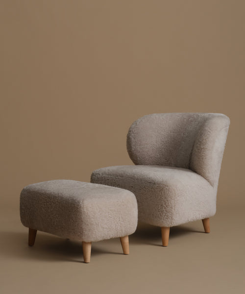 Beige armchair and ottoman set on a brown background