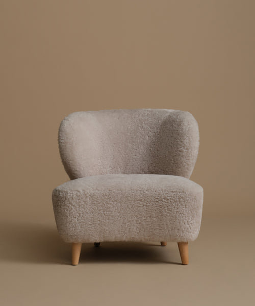 Light brown textured armchair on a brown background