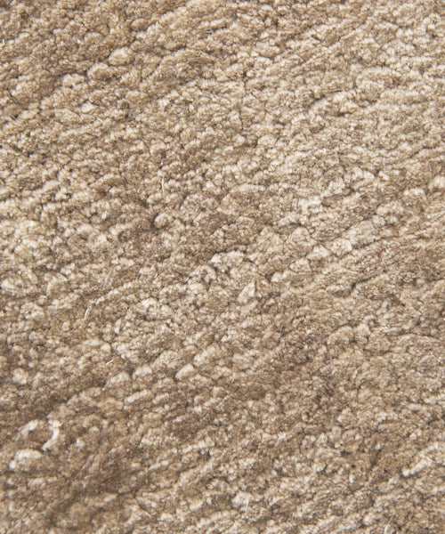 Close-up of the Rug Swatch in beige, featuring a soft, textured, and slightly mottled surface. The mocha-toned fibers look plush and dense, giving the swatch a cozy, warm appearance.