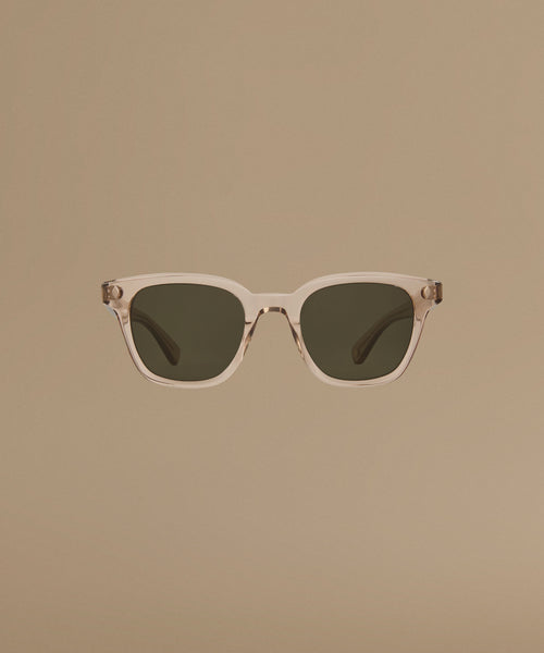 Sunglasses with a clear frame and dark lenses on a beige background