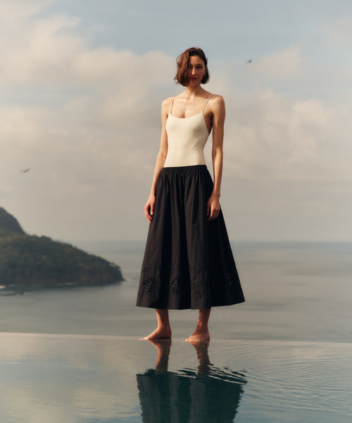 Woman standing in shallow water with a scenic background