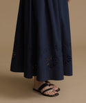 Navy blue skirt with cut-out patterns on a beige background