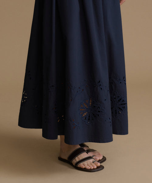 Navy blue skirt with cut-out patterns on a beige background