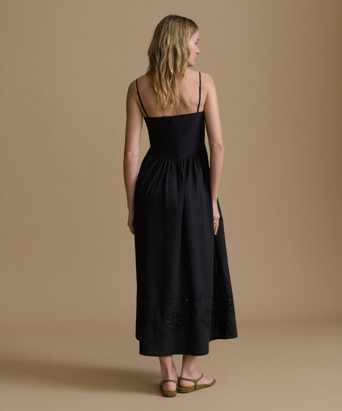 Woman wearing a black dress against a beige background