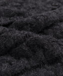 Close-up of dark gray or black knit fabric with a soft, fluffy texture and visible fibers, similar to the plush Peruvian yarn used in the Cable Juliette Cardigan.