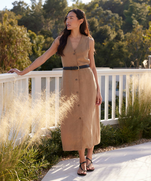 A woman in the Callan Dress stands on the sidewalk, showcasing this timeless piece thats perfect for any occasion.