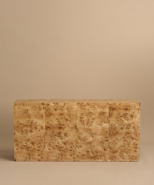 A rectangular Carbon Dresser with a smooth, light brown surface and a distinctive swirling grain pattern reminiscent of burlwood, set against a plain beige background.