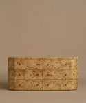 A six-drawer burlwood dresser in warm beige and brown tones, set against a solid beige background.