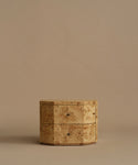 A burlwood nightstand with drawers, featuring natural burl wood grain and small dark metal knobs, set against a solid beige background.