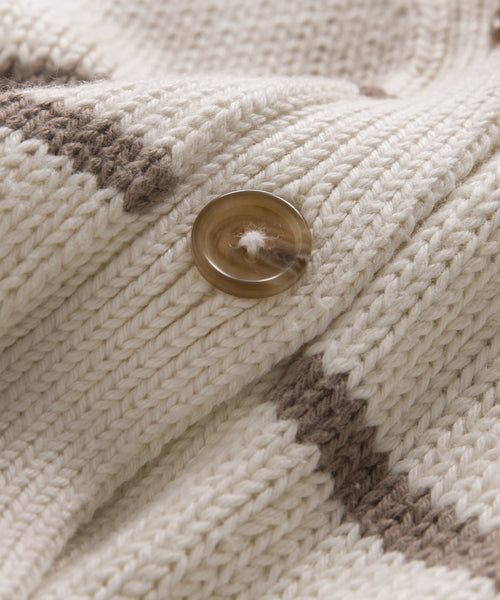 Close-up of a brown button sewn onto ribbed knit fabric with an ivory taupe stripe, highlighting the Chloe Cardigan. The detailed yarn and stitching are visible, making it ideal for warm-weather wear.