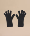 A pair of black Cashmere Alpine Gloves is laid flat side by side on a light beige background, offering a stylish way to elevate your winter look.