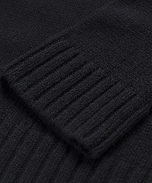 Close-up of the Cashmere Amelia Crewneck in black, highlighting the ribbed cuffs texture as it rests over the main body for a cozy, luxurious feel.