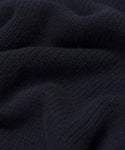 Close-up of the Cashmere Amelia Crewneck’s black chunky knit fabric, showing its ribbed texture and soft, wavy folds—ideal for an oversized sweater look.