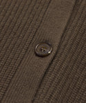 Close-up of the brown, textured lightweight knit fabric and round button of the Cashmere Cocoon Cardigan, highlighting detailed threads and the buttonhole seam.