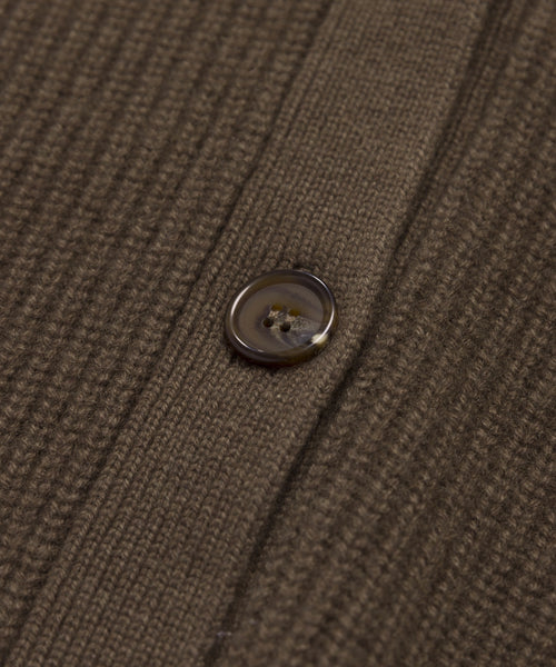 Close-up of the brown, textured lightweight knit fabric and round button of the Cashmere Cocoon Cardigan, highlighting detailed threads and the buttonhole seam.