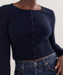 A person wearing the Cashmere Finley Cardigan in dark navy with a shrunken fit and fitted waist, paired with high-waisted dark denim jeans. The image is cropped to show only the torso.