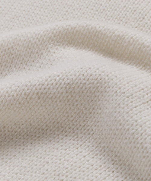 Close-up of the Cashmere Jet Turtleneck's cream-colored lightweight knit fabric, highlighting its soft texture and gentle folds—ideal for an oversized turtleneck look.
