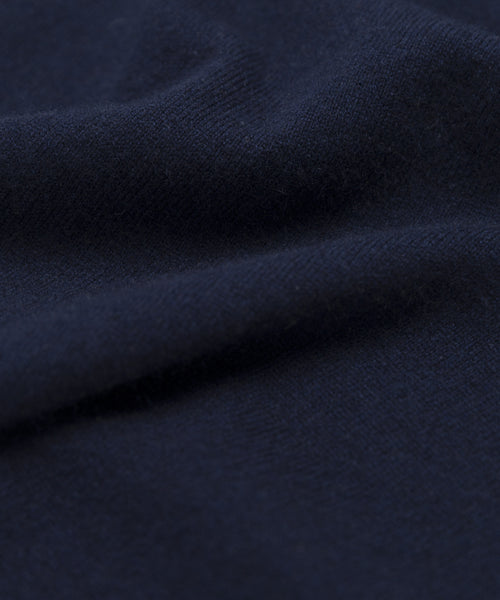 A close-up of dark navy blue fabric with a soft, smooth texture and gentle folds, perfect for the springweight Cashmere Marina Crewneck.