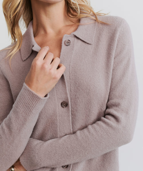 A person wearing the Murphy Cardigan in light mauve, buttoned-up with a collar, holds the top near the buttons. The image is cropped at the shoulders and mid-torso.