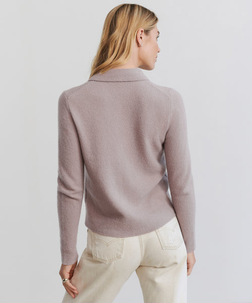 A woman with blonde hair wearing the Murphy Cardigan in light lavender and cream-colored pants is shown from the back against a plain light background.