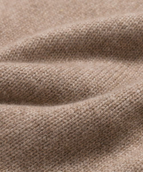 Close-up of a soft, beige knitted fabric with visible texture and gentle folds, highlighting the fine weave and cozy feel—ideal for the Cashmere Oversized Crewneck.