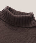 Close-up of the Cashmere Porter Turtleneck in brown, featuring ribbed collar detailing and a textured knit body, set against a plain light background.