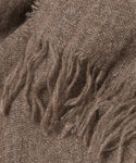 Close-up of a brown, lightweight Cashmere Shawl with a soft texture and loose, frayed fringe along the edge—ideal as a cozy travel scarf.