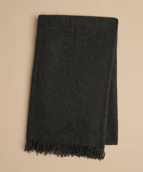 A folded dark gray Cashmere Shawl with fringe detailing at the edge, displayed on a light beige background.