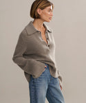 Model wearing sweater with ribbed, exaggerated collar, buttoned neck and bell sleeves.