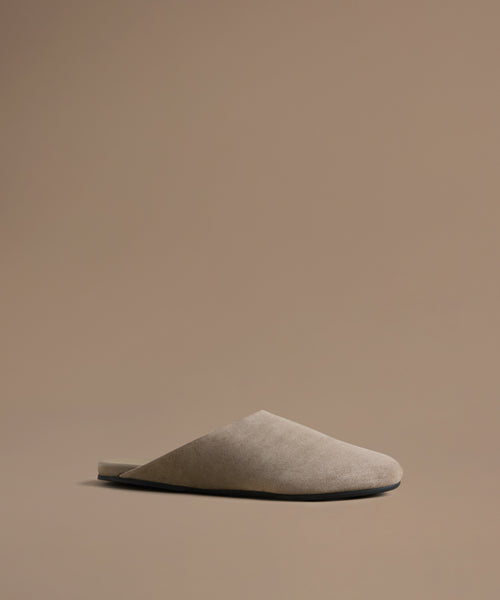 Beige mule on a brown background