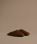 Pair of brown mules on a beige background