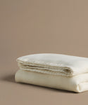 Folded beige comforter on a beige background