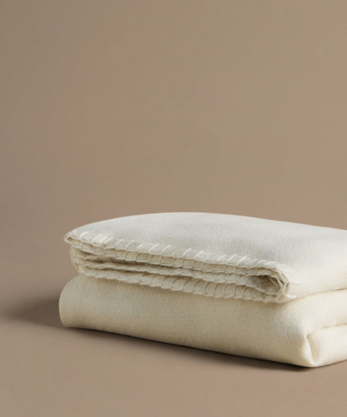Folded beige comforter on a beige background