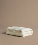 Folded beige blanket on a beige background
