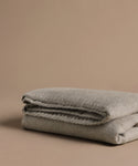 Folded gray blanket on a beige background