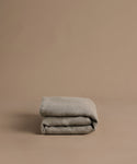 Folded gray blanket on a brown background
