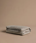 Folded gray blanket on a brown background