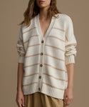 Woman wearing a cream and beige striped cardigan on a brown background