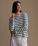 Woman wearing a blue and white striped shirt against a beige background