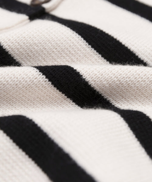 Close-up of the Cooper Cardigan, a soft knit with horizontal ivory and black stripes. The detailed texture showcases slight folds in the fabric, emphasizing its structured silhouette.
