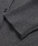 A close-up of a Cooper Cardigan sleeve in dark grey, highlighting the ribbed cuff, part of the body, and visible black buttons.