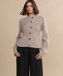 A woman poses for a picture in the Cooper Cardigan, highlighting its structured silhouette.