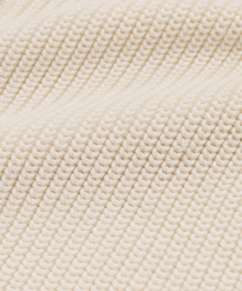Close-up of cream-colored, ribbed knit with a textured, wavy surface—ideal for the Cotton Hayes Crewneck Cardigan, perfect as a lightweight summer layer or cozy cotton sweater.