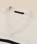 Close-up of the Cotton Kate V-Neck, a cream-colored striped sweater with a ribbed cotton V-neck collar and black label inside the neckline. A dark horizontal stripe adds to its classic spring knit style.